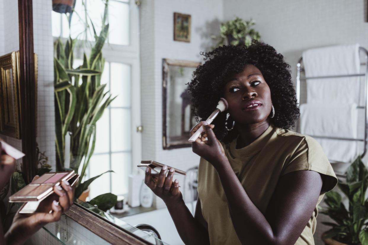 Woman using make-up brushes in the bathroom. (Getty Images)