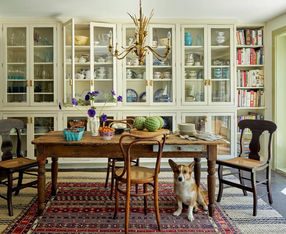 In the kitchen, cabinets by Over Mountain Builders hold ten Have’s extensive collection of china. Antique dining table; Turkish rug atop Bunny Williams rug.