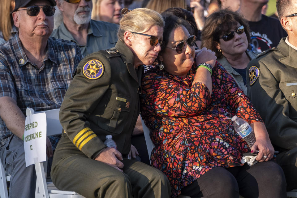 Wife of slain Ventura County Sheriff's Deputy Ron Helus, Karen Helus is comforted by Undersheriff Monica McGrath during the dedication of the Borderline Healing Garden at Conejo Creek Park in Thousand Oaks, Calif., Thursday, Nov. 7, 2019. The dedication marked the anniversary of a fatal mass shooting at a country-western bar a year earlier. (Hans Gutknecht/The Orange County Register via AP)