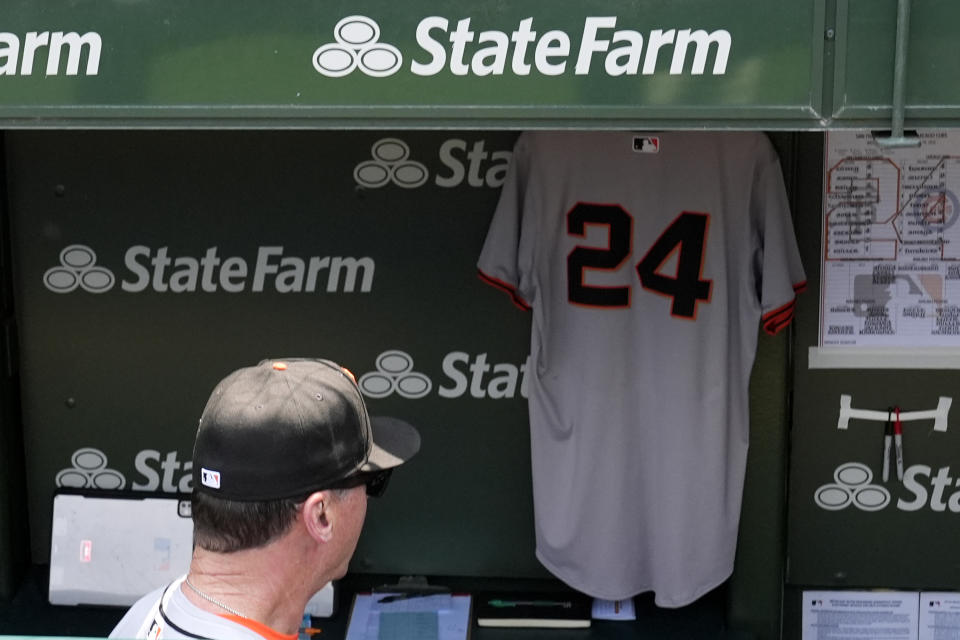 San Francisco Giants manager Bob Melvin looks at the jersey of former San Francisco Giants player Willie Mays in the dugout before a baseball game against the Chicago Cubs in Chicago, Wednesday, June 19, 2024. (AP Photo/Nam Y. Huh)