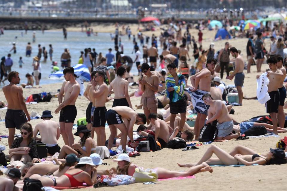 People enjoy the warm weather on Melbourne's St Kilda Beach.