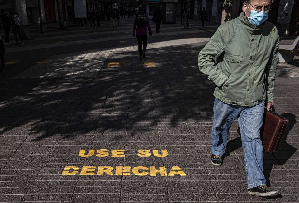 Un hombre pasa junto al mensaje "Use su derecha" en la emblemática zona peatonal Paseo Ahumada en Santiago, Chile, el miércoles 12 de agosto de 2020. (AP Foto/Esteban Felix)