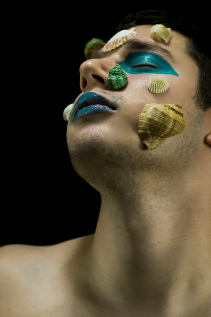 A merman in reverie with shells attached to his face