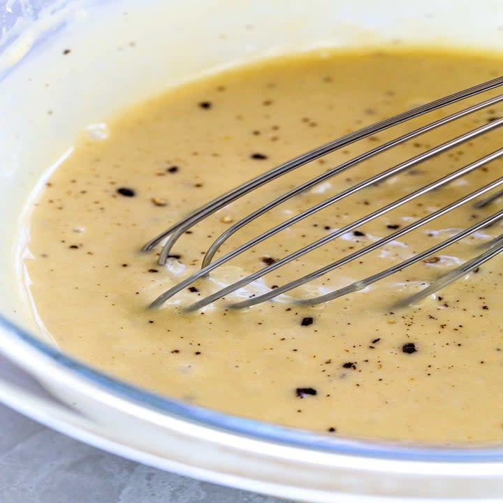 Whisking homemade Caesar dressing.