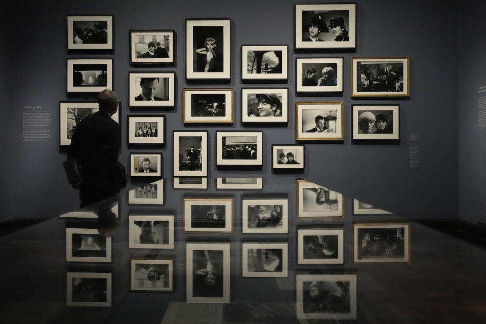 A visitor looks at pictures during a preview of Paul McCartney Photographs 1963-64: Eyes of the Storm exhibition at the National Portrait Gallery in London, Britain, Tuesday, June 27, 2023. The exhibition consists of unseen photographs taken by Paul McCartney from the Beatles at the height of Beatlemania. The gallery will open it's doors from June 28, 2023 until October 1, 2023. (AP Photo/Frank Augstein)