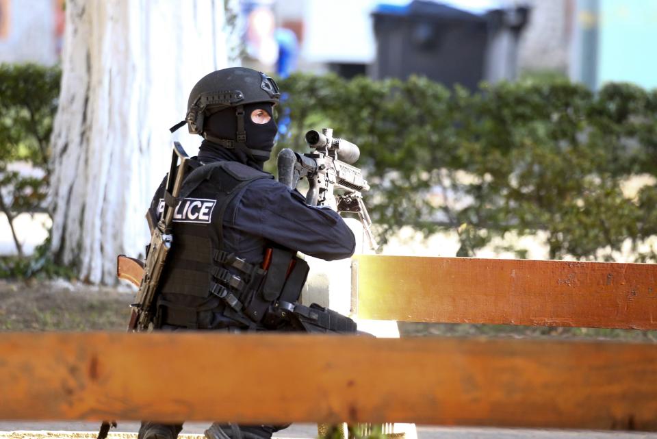 A Georgian police officer takes his position near a bank where an armed assailant took several people hostage in the town of Zugdidi in western Georgia, Wednesday, Oct. 21, 2020. The Georgian Interior Ministry didn't immediately say how many people have been taken hostage in the town of Zugdidi in western Georgia, or what demands the assailant has made. Police sealed off the area and launched an operation "to neutralize the assailant," the ministry said in a statement. (AP Photo/Zurab Tsertsvadze)