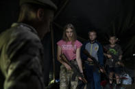 Tres niños que participan en un campamento en el que nacionalistas ucranianos les enseñan a combatir, e incluso matar, a los sectores pro-rusos, escuchan fusil en mano a un instructor cerca de Ternopil, Ucrania, el 28 de julio del 2018, (AP Photo/Felipe Dana)