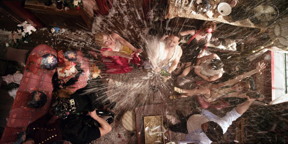 an overhead shot of a party and someone spritzing champagne everywhere
