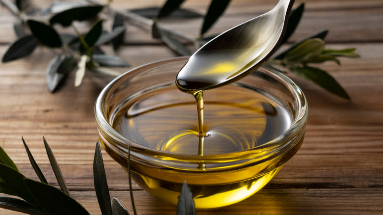 pouring spoonful of olive oil