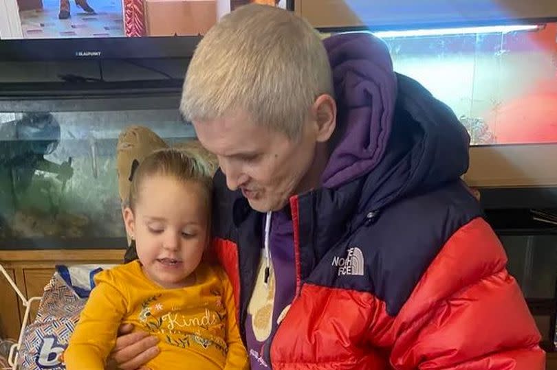 Ali Cowper reading a storybook for his youngest grandchild, Ava