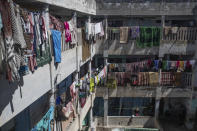 In this in Wednesday, March 25, 2020 photo, a man stands outside his room in an overcrowded housing complex in Sale, near Rabat, Morocco. Hundreds of people live in crowded rooms in this Moroccan housing complex with no running water and no income left because of the coronavirus lockdown measures. However volunteers come to help clean as the government tries to protect the population from virus while not punishing the poor. (AP Photo/Mosa'ab Elshamy)