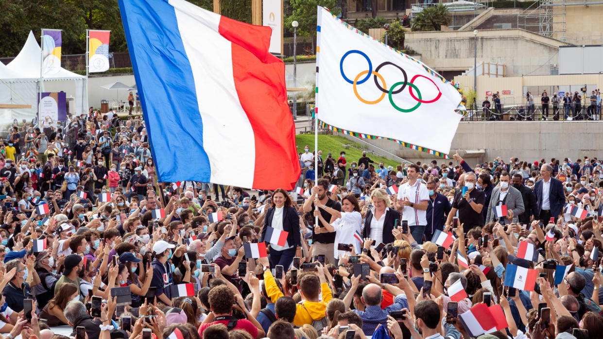  French flag and Olympic flags in a crowd of people for the 2024 summer games. 