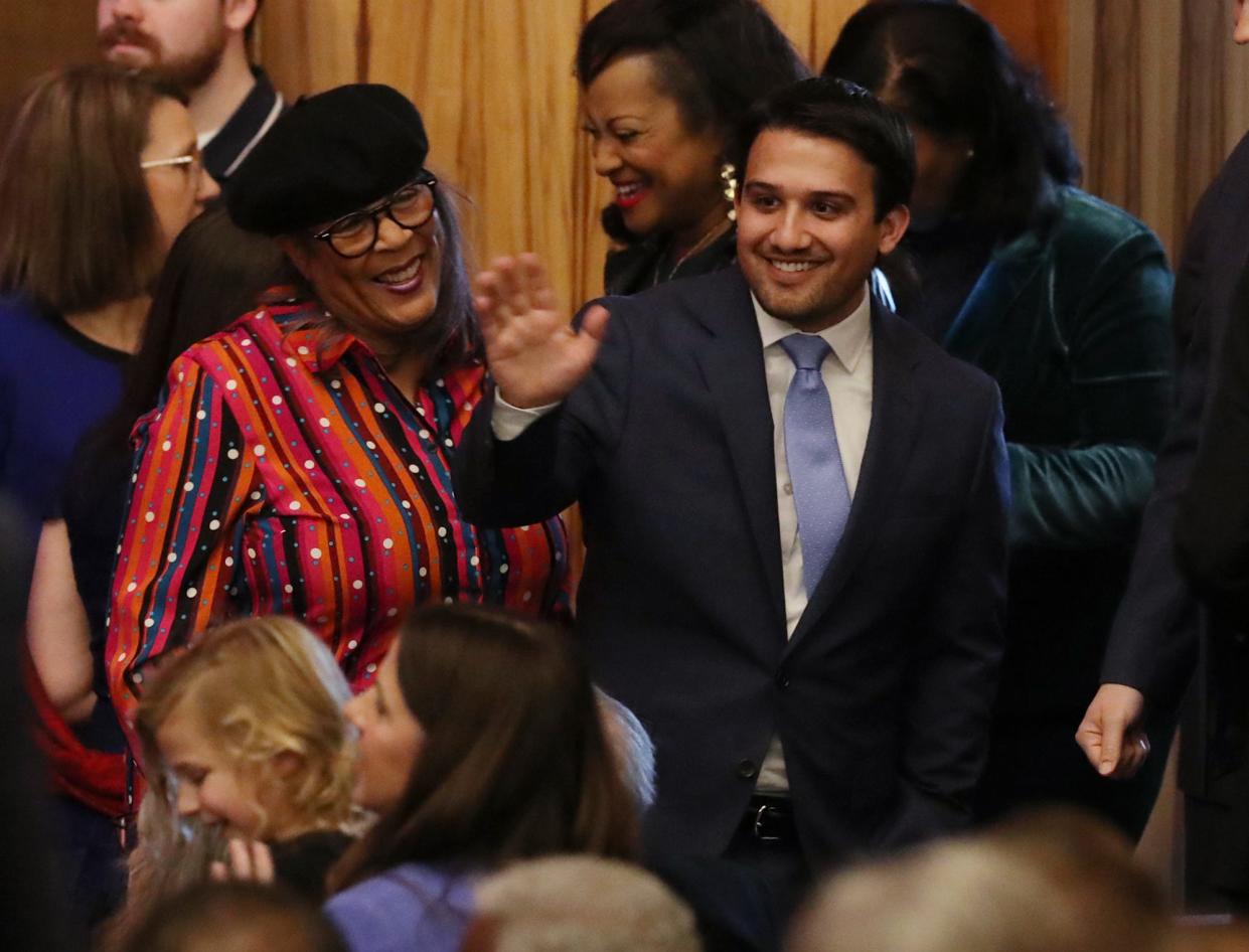 Summit County Council member Veronica Sims, left, looks on as Akron Mayor Shammas Malik waves to a supporter before his ceremonial swearing-in as mayor during a public ceremony at EJ Thomas Hall on Saturday.