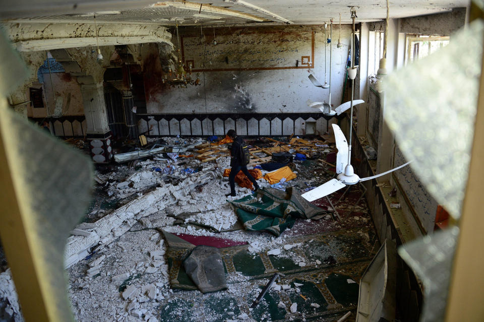 <p>An Afghan media personnel walks through a Shiite mosque after it was attacked by suicide bombers in Herat on August 2, 2017. (Photo: Hoshang Hashimi/AFP/Getty Images) </p>