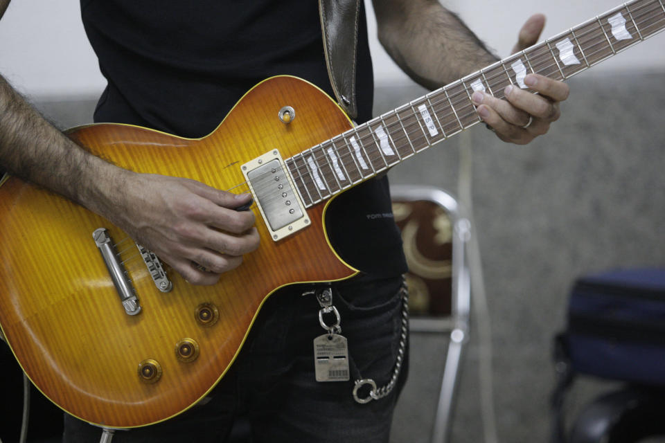 In this picture taken on Friday, Feb. 1, 2013, Iranian guitarist Hamed Babaei practices for his band called "Accolade" in a basement of a house in Tehran, Iran. Heavy metal guitarists jamming in basements. Headphone-wearing disc jockeys mixing beats. Its an underground music scene that is flourishing in Iran, despite government restrictions. (AP Photo/Vahid Salemi)