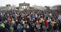 FILE - In this Wednesday, Nov. 18, 2020 file photo, people attend a protest rally in front of the Brandenburg Gate in Berlin, Germany against the coronavirus restrictions in Germany. Nations are struggling to reconcile cold medical advice with a holiday tradition that calls for big gatherings in often poorly ventilated rooms, where people chat, shout and sing together, providing an ideal conduit for a virus that has killed over 350,000 people in Europe so far. (AP Photo/Michael Sohn, File)