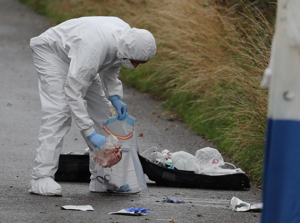 A police investigator places items in a bag at the scene of an incident, near Sulhamstead, Berkshire, where a Thames Valley Police officer was killed whilst attending a reported burglary on Thursday evening.