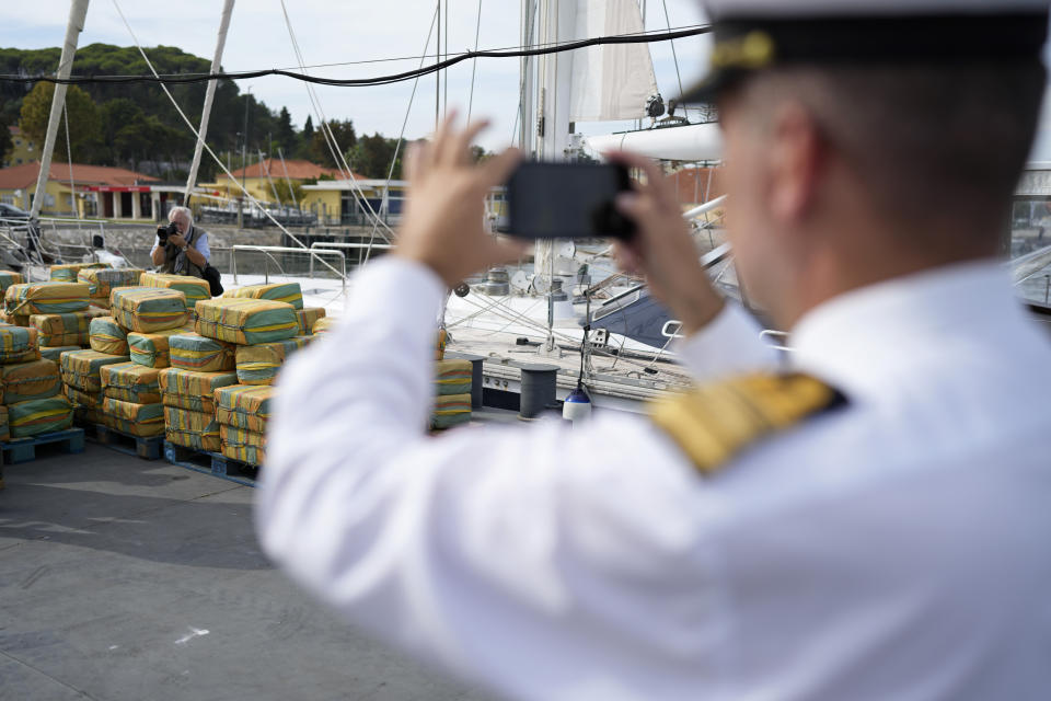 A Portuguese Navy officer takes pictures of bales of cocaine weighting some 5,2 tons and a seized yacht displayed for the media at a Portuguese Navy base in Almada, south of Lisbon, Monday, Oct. 18, 2021. Portuguese police said Monday the seizure was the largest in Europe in recent years and the biggest in Portugal for 15 years. Police localized and intercepted the 24-meter (79-foot) yacht at sea. The operation involved police from Portugal, Spain, the Drug Enforcement Agency in the United States and the United Kingdom's National Crime Agency. (AP Photo/Armando Franca)