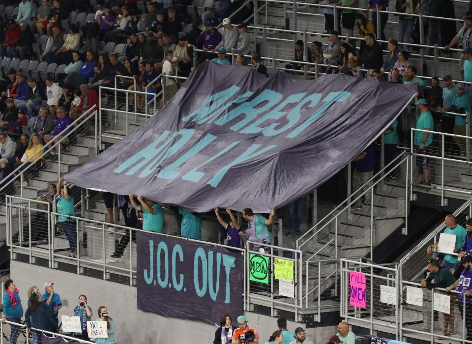 Racing Louisville FC fans held up a banner that said "Arrest Holly" during the Louisville City FC match against Detroit City FC at the Lynn Family Stadium in Louisville, Ky. on Oct. 5, 2022.  They were supporting the players on the Racing Louisville FC team after allegations that former head coach Christy Holly abused players.