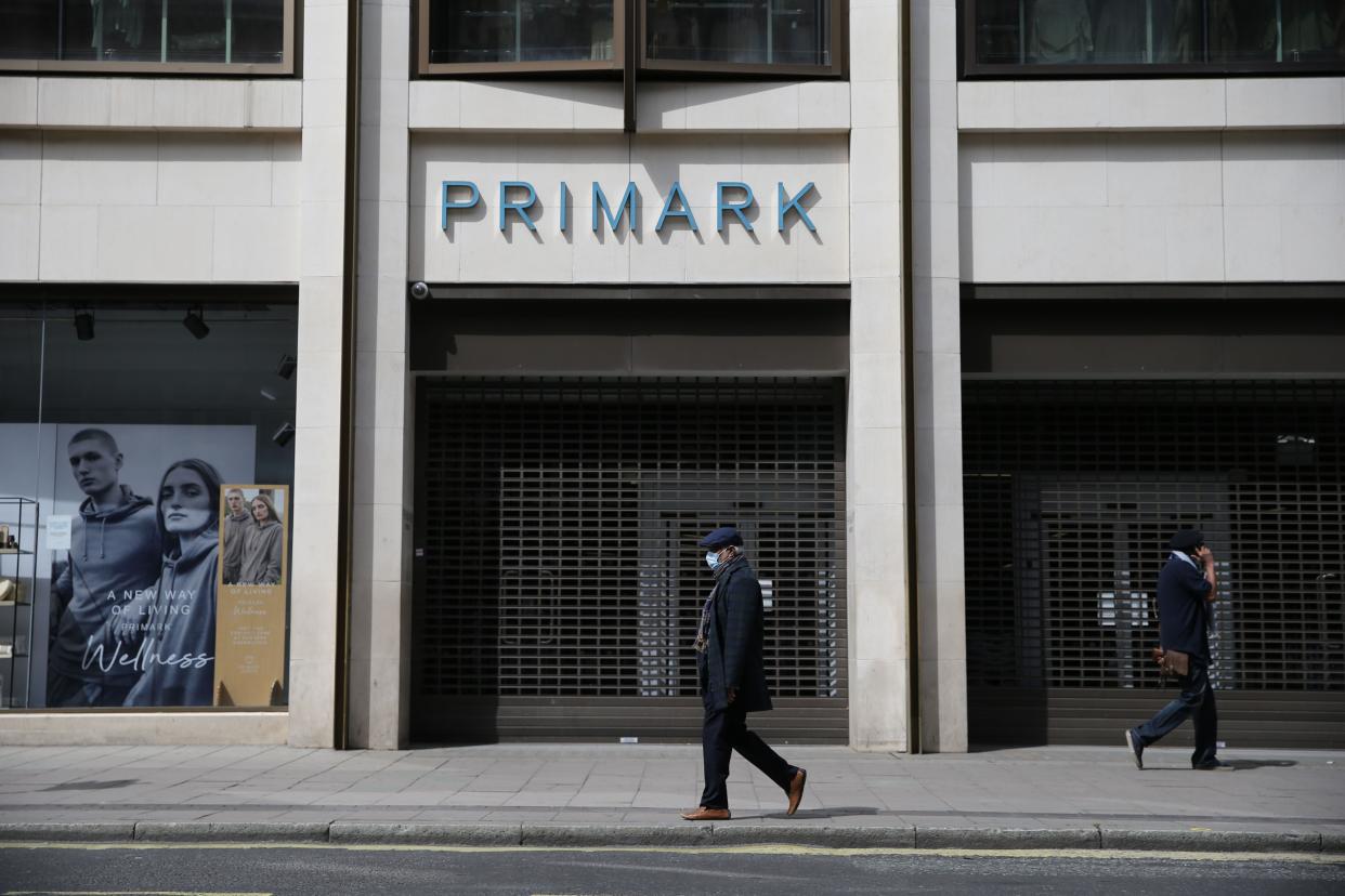 <p>A masked man walks past a closed Primark store in London’s Oxford Street in May 2020</p> (AFP/Getty)