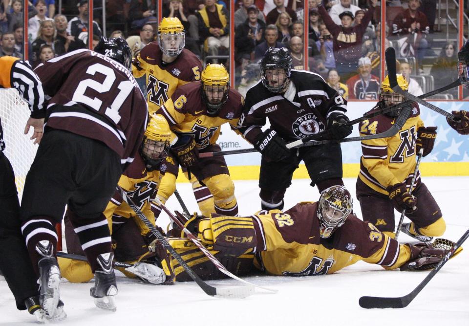 Minnesota's Adam Wilcox, bottom right, reaches as Union's Mike Vecchione, left, shoots the puck for a goal during the first period of an NCAA men's college hockey Frozen Four tournament game on Saturday, April 12, 2014, in Philadelphia. (AP Photo/Chris Szagola)