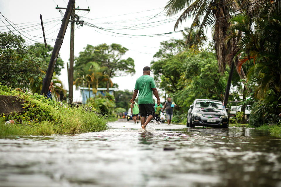Residents wade through the flooded streets in Fiji's capital city of Suva on Dec. 16, 2020, ahead of super Cyclone Yasa. (Leon Lord / AFP via Getty Images file)