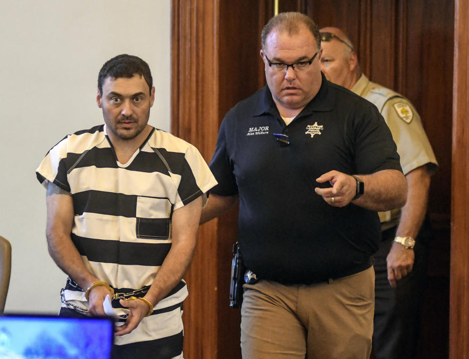 Oxford Police Officer Matthew Kinne, center, is escorted into a hearing by Lafayette County Sheriff Dept. Maj. Alan Wilburn at the Lafayette County Courthouse, Wednesday, May 22, 2019, in Oxford, Miss. Kinne is charged in the death of 32-year-old Dominique Clayton, who was found dead Sunday. (Bruce Newman/The Oxford Eagle via AP)