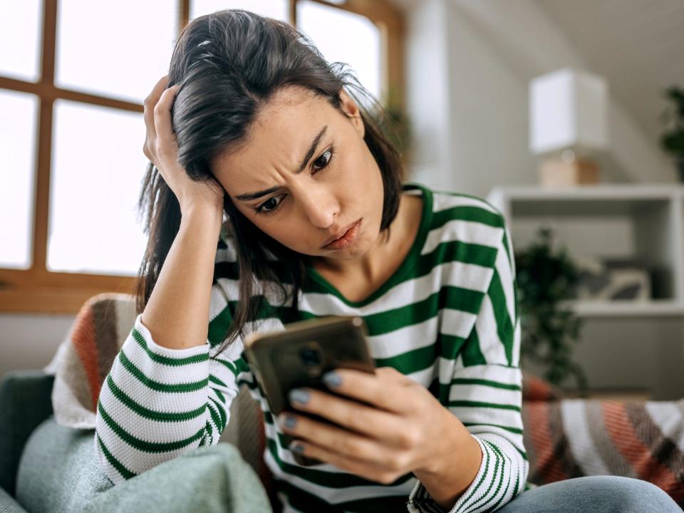 Symbolbild: Eine frustrierte Frau schaut auf ihr Smartphone. - Copyright: Getty Images