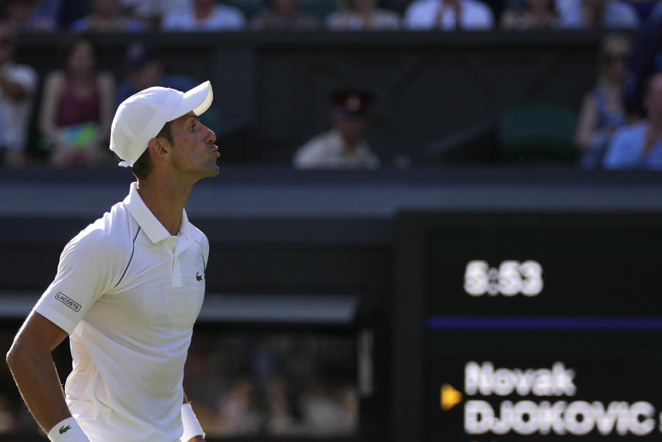 Serbia's Novak Djokovic blows kisses to the crowd as he celebrates after beating Britain's Cameron Norrie in a men's singles semifinal on day twelve of the Wimbledon tennis championships in London, Friday, July 8, 2022. (AP Photo/Alastair Grant)