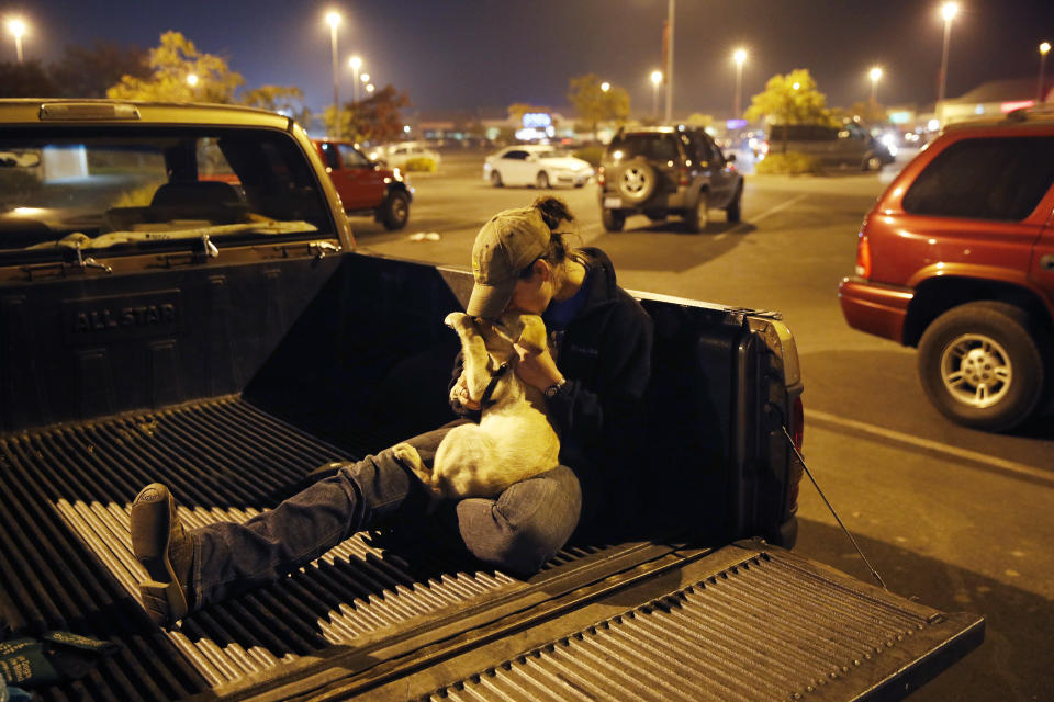 <p>Sarah Gronseth kisses her dog Branch in the bed of a truck in a parking lot, Nov. 13, 2018, in Chico Calif. Gronseth, a teacher, evacuated some of her high school students in her truck as the fire bore down on the high school in Paradise, Calif. She lost her home in the fire. (Photo: John Locher/AP) </p>