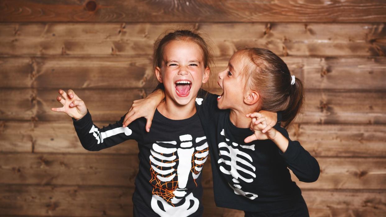 friends on halloween wearing matching skeleton shirts