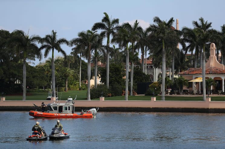 A Coast Guard boat and law enforcement officers on personal watercraft patrol in front of the Mar-a-Lago resort