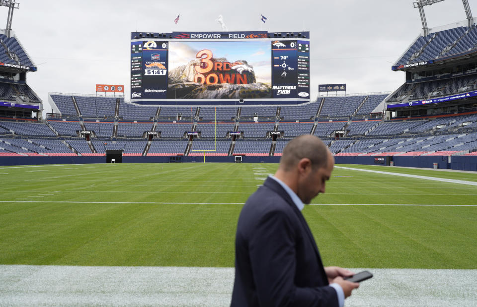 Zach Myhra senior project director at Empower Field at Mile High, checks his mobie device during a media tour to show the $100-million upgrades made to Empower Field at Mile High, the home to the NFL football team, Friday, Aug. 25, 2023, in Denver. The upgrades include a new scoreboard, which is the fifth-largest in the league, as well as premium hospitality areas, renovated suites and team store plus artwork scattered throughout the stadium featuring the Broncos' history. (AP Photo/David Zalubowski)