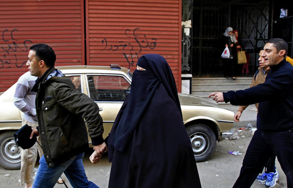 Egyptian plainclothes policemen arrest a female supporter of Egypt’s ousted Islamist President Mohammed Morsi during clashes in Cairo, Egypt, Friday, Jan. 3, 2014. The confrontations spilled from main streets to side streets in heavily populated residential areas in several provinces including Cairo, Giza and Alexandria. Dozens of Muslim Brotherhood members and supporters hurled rocks at security forces, which responded with volleys of tear gas. Arabic reads, "Sissi is a killer." (AP Photo/Ahmed Abd El Latif, El Shorouk newspaper)