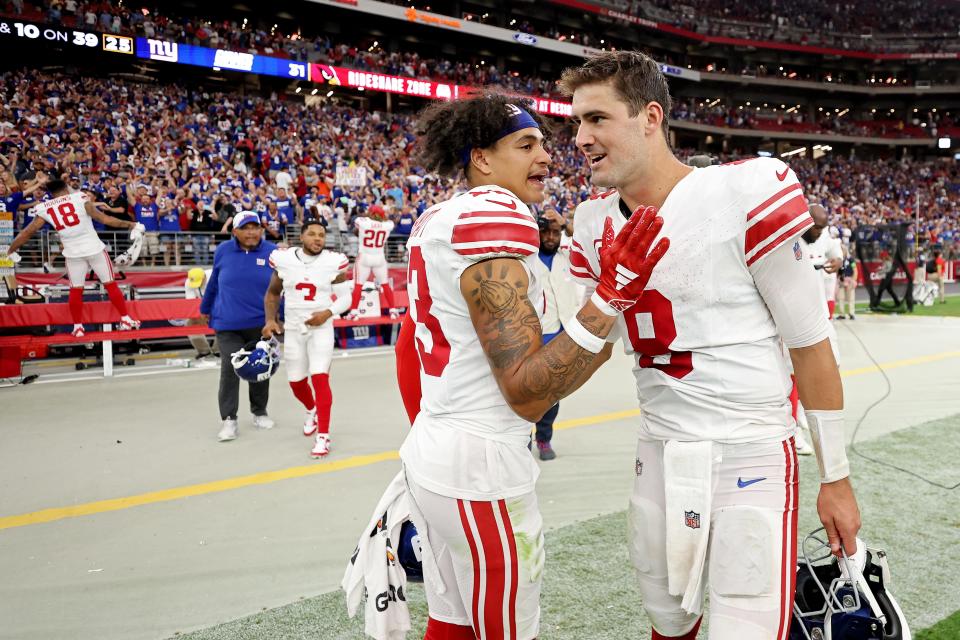 Jalin Hyatt #13 of the New York Giants celebrates with Daniel Jones #8 after a win over the Arizona Cardinals at State Farm Stadium on September 17, 2023 in Glendale, Arizona.