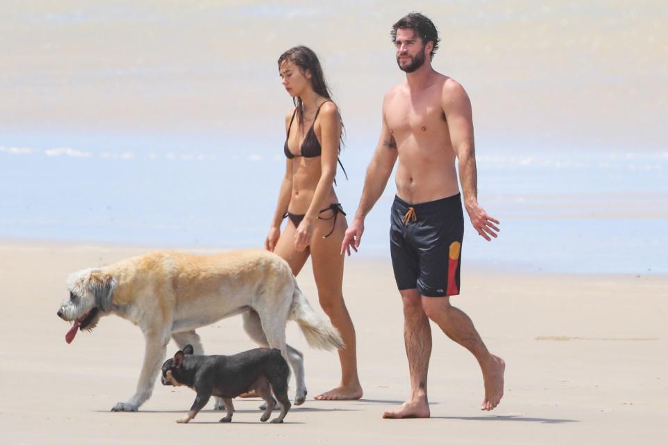 <p>Liam Hemsworth and girlfriend Gabriella Brooks take their dogs out for a walk on the beach in Australia on Wednesday.</p>