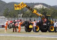 Workers remove the car of Lotus Formula One driver Kimi Raikkonen of Finland after it crashed during the first practice session of the Korean F1 Grand Prix at the Korea International Circuit in Yeongam October 4, 2013. REUTERS/Lee Jae-Won (SOUTH KOREA - Tags: SPORT MOTORSPORT F1)