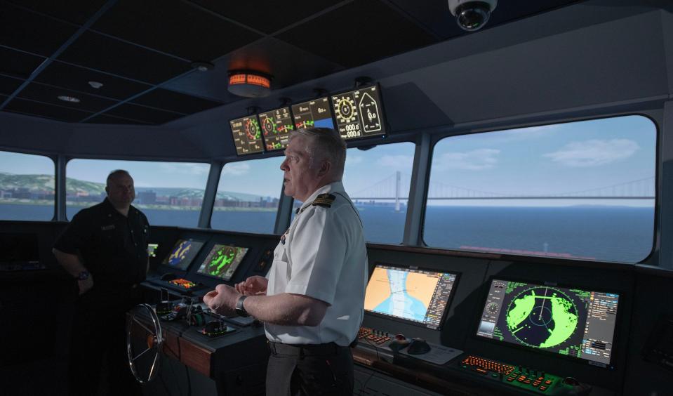 Massachusetts Maritime Academy staff member Capt. Mike Burns speaks to media representatives Tuesday inside the school's bridge, talking about the cargo ship striking a column of a bridge earlier on Tuesday in Baltimore, Maryland. The backdrop of the simulator is the Verrazzano-Narrows Bridge in New York City.