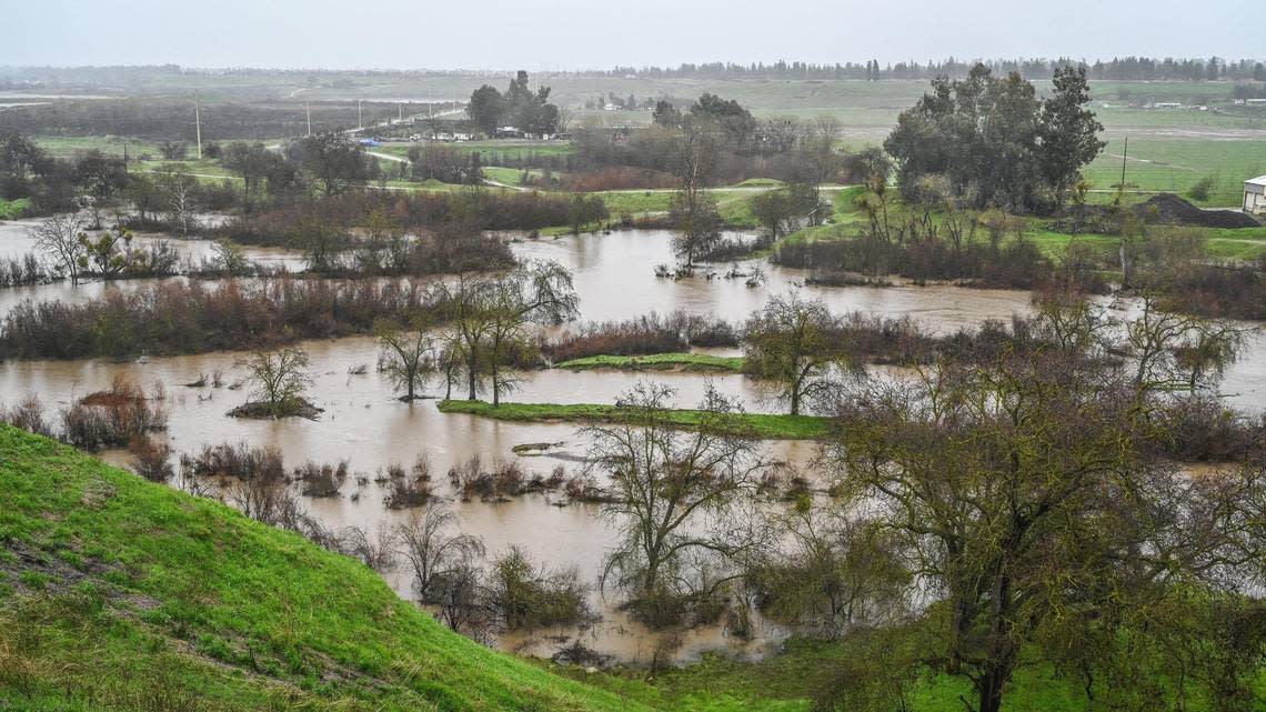 San Joaquin River water can be seen swelling along the banks between Fresno and Madera counties as rain continues during an atmospheric river event on Saturday, Jan. 14, 2023.