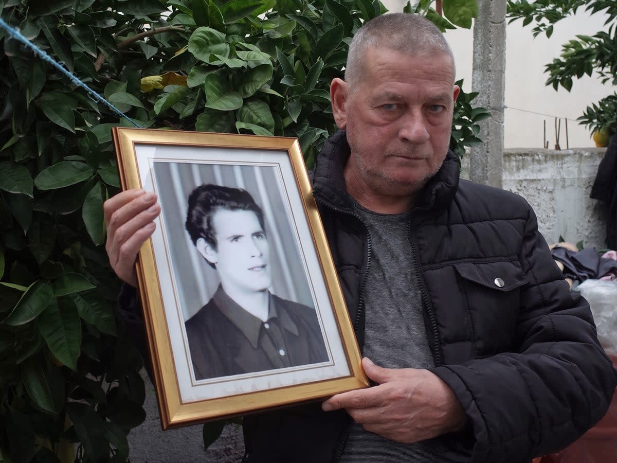 Zef Ndoj, holding a photo of his brother, whose body he found after more than 20 years  (Eleanor Myers)