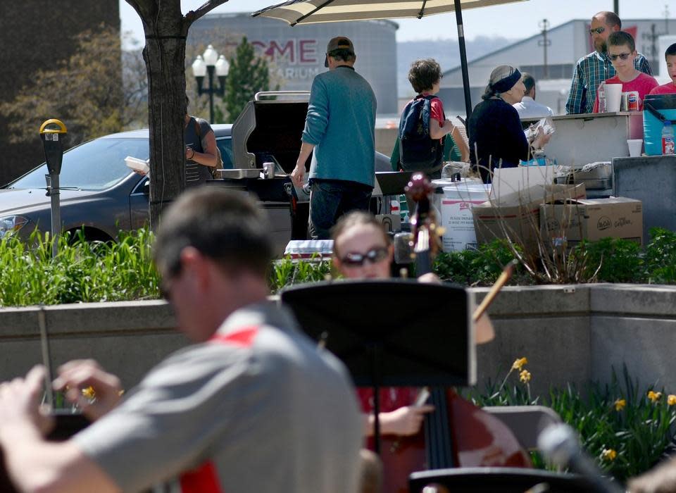 In this 2018 photo, the Morton Junior High seventh-grade orchestra plays outside the Peoria County Courthouse while in the background Loreece Haddad serves customers at the pushcart for Haddad's Restaurant.