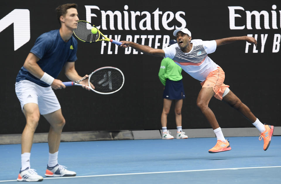 Rajeev Ram, right, of the US and Britain's Joe Salisbury in action against Croatia's Ivan Dodig and Slovakia's Filip Polasek in the men's doubles final at the Australian Open tennis championship in Melbourne, Australia, Sunday, Feb. 21, 2021.(AP Photo/Andy Brownbill)