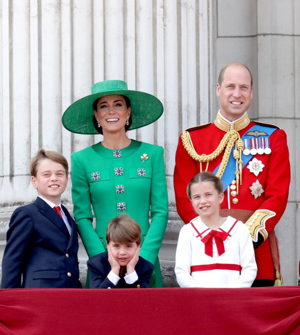 prince george, prince louis, princess kate, princess charlotte, and prince william stand on a balcony and smile