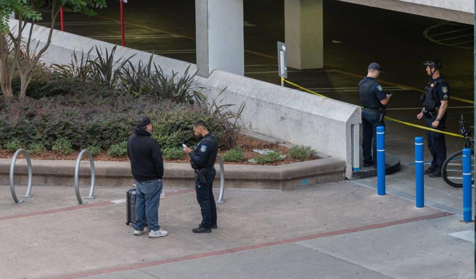 A Sacramento Police officer conducts and interview Tuesday after a man who barricaded himself atop a downtown parking garage was fatally shot by police during a standoff. The incident began just after 1 a.m. when the man was reported in the Downtown Plaza West parking garage at Third and L streets with a weapon.