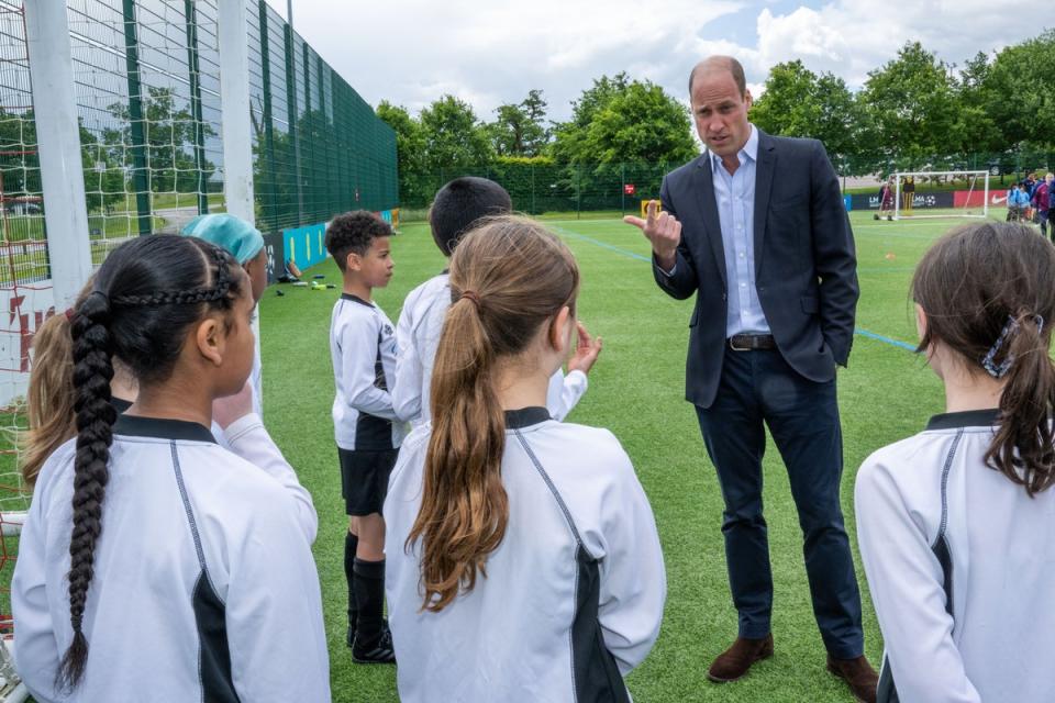 The Prince of Wales speaks with schoolchildren during a visit to St George’s Park (Paul Cooper/The Telegraph/PA Wire)