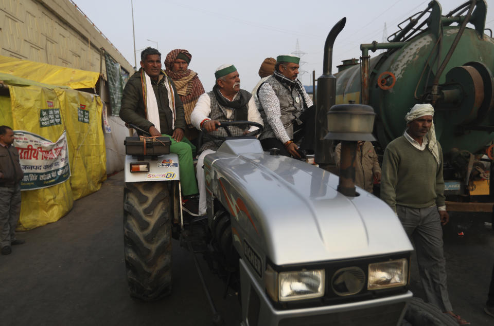 Indian Farmers arrive in a tractor for their tractor rally planned for Jan. 26 in protest against new farm laws, at Delhi-Uttar Pradesh border, India, Friday, Jan. 22, 2021. Talks between protesting farmers’ leaders and the government ended abruptly in a stalemate on Friday with the agriculture minister saying he has nothing more to offer than suspending contentious agricultural laws for 18 months. The farmers’ organizations in a statement on Thursday said they can’t accept anything except the repeal of the three new laws. (AP Photo/Manish Swarup)