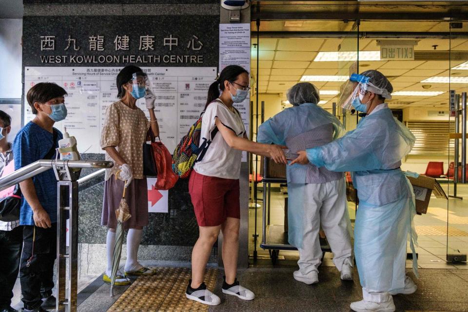 Residents are given three coronavirus testing kits (AFP via Getty Images)