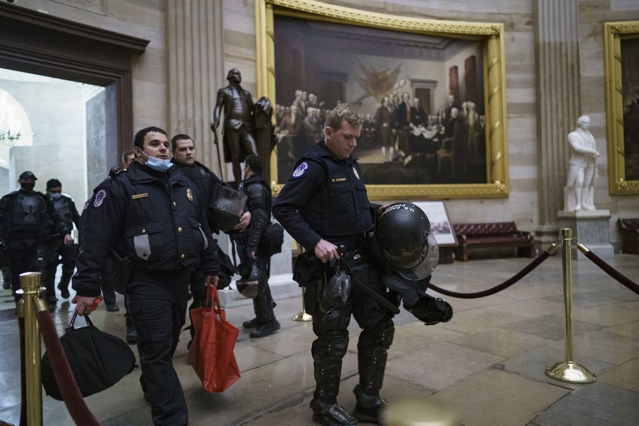 U.S. Capitol Police officers walk through the Rotunda as they and other federal police forces responded as violent protesters loyal to President Donald Trump stormed the U.S. Capitol today, at the Capitol in Washington, Wednesday, Jan. 6, 2021.