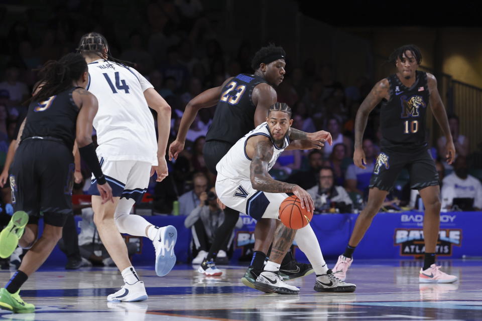 In a photo provided by Bahamas Visual Services, Villanova's Justin Moore, center bottom, controls the ball during an NCAA college basketball game against Memphis in the Battle 4 Atlantis at Paradise Island, Bahamas, Friday, Nov. 24, 2023. (Tim Aylen/Bahamas Visual Services via AP)