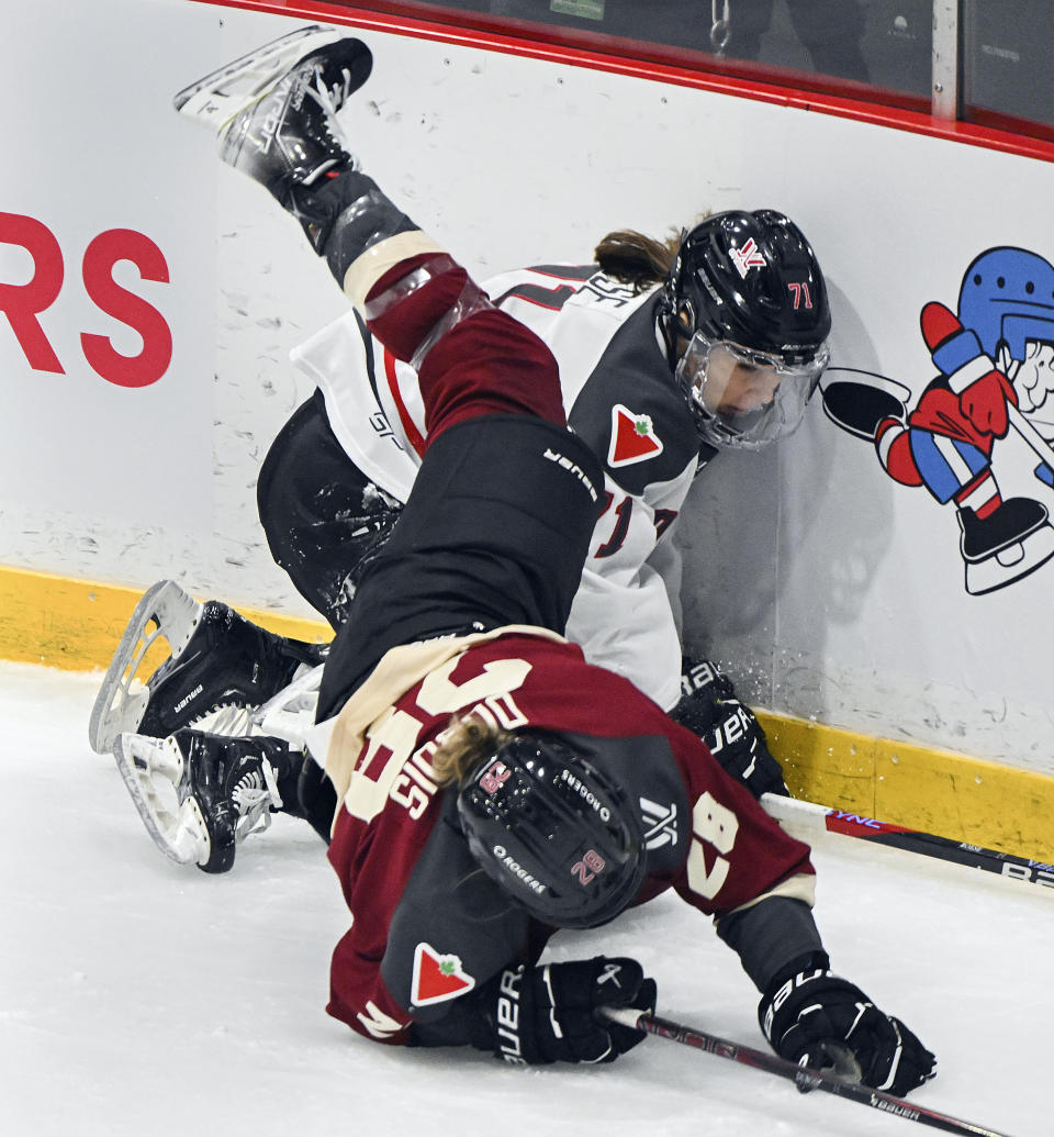 Montreal's Catherine Dubois (28) collides with Ottawa's Jincy Roese (71) during the first period of a PWHL hockey game in Montreal, Saturday, Feb. 24, 2024. (Graham Hughes/The Canadian Press via AP)